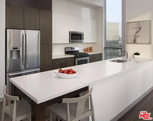 a kitchen with a table a refrigerator and a sink