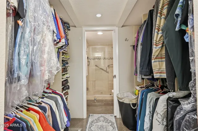 a view of walk in closet with clothes and shoes