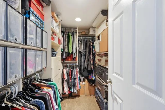 a view of walk in closet with clothes