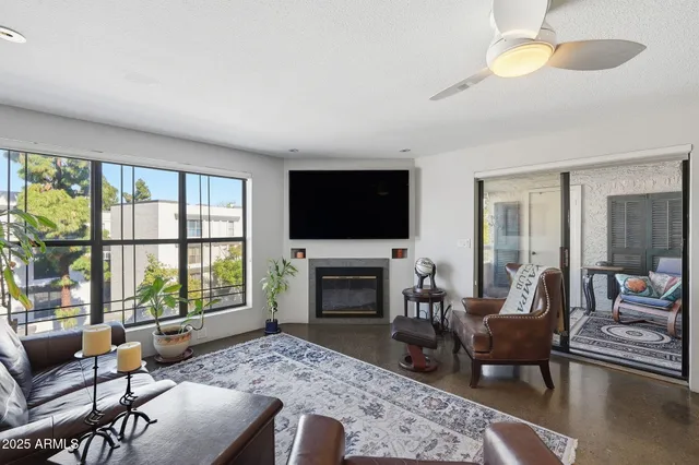a living room with furniture a fireplace and a flat screen tv