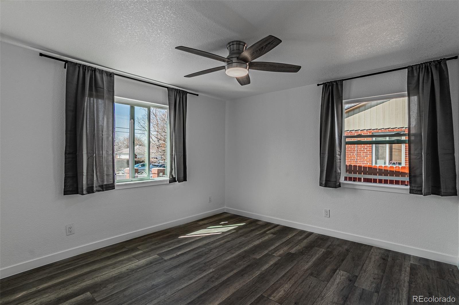 3360 Magnolia Street Denver, CO 80207 - Photo 12 of 31 a view of empty room with wooden floor and fan