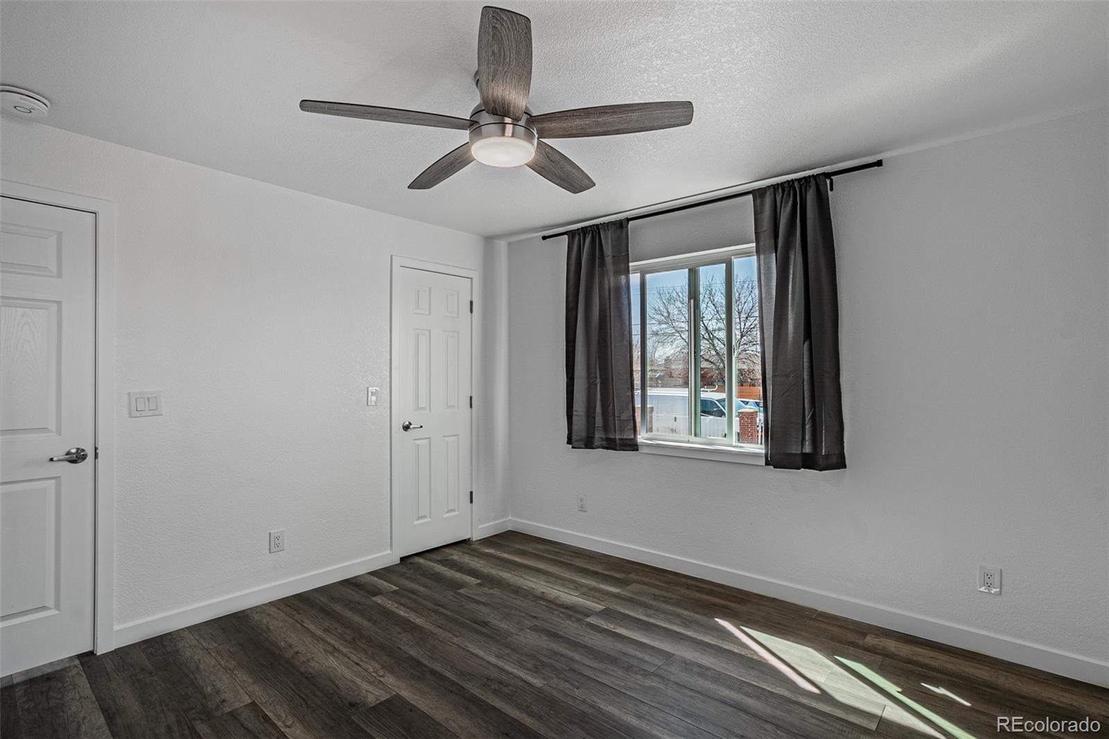 3360 Magnolia Street Denver, CO 80207 - Photo 13 of 31 a view of an empty room with wooden floor and a window