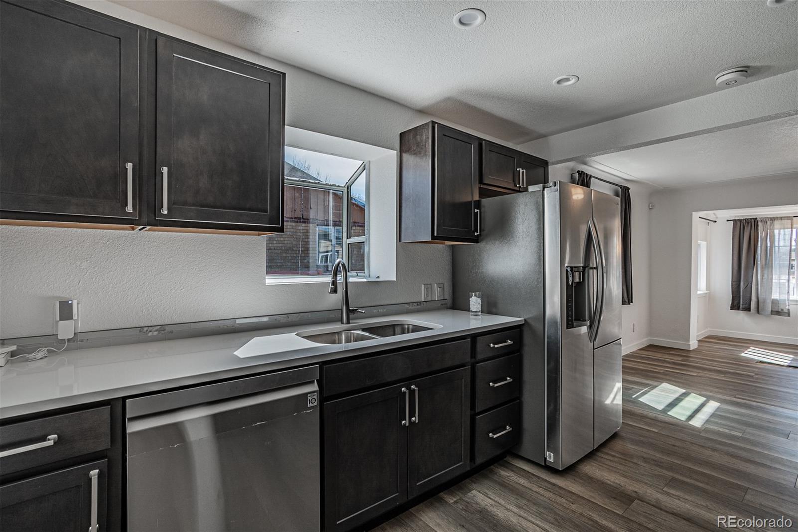 3360 Magnolia Street Denver, CO 80207 - Photo 16 of 31 a kitchen with stainless steel appliances granite countertop a sink refrigerator and cabinets