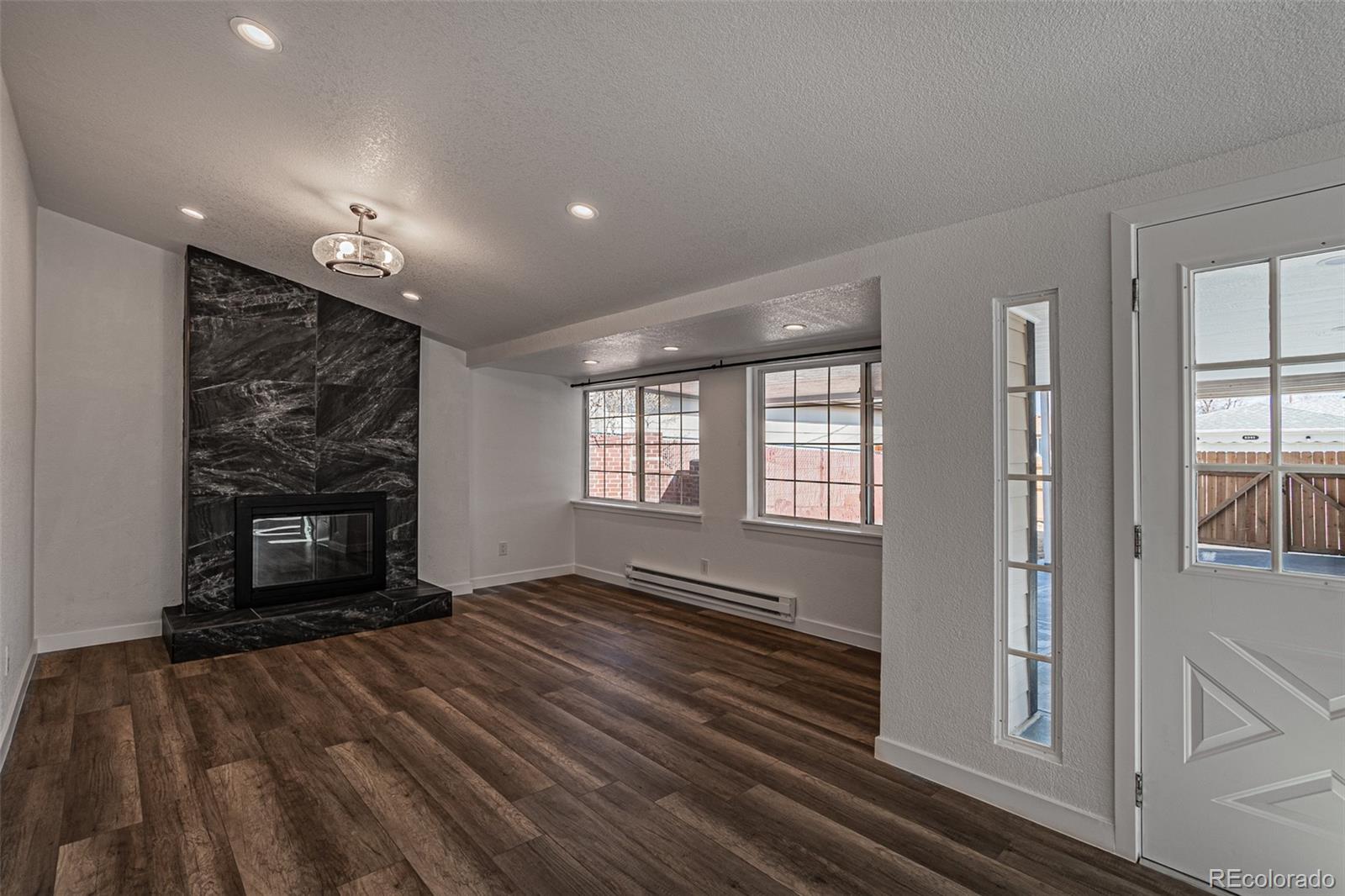 3360 Magnolia Street Denver, CO 80207 - Photo 17 of 31 a view of an empty room with wooden floor fireplace and a window