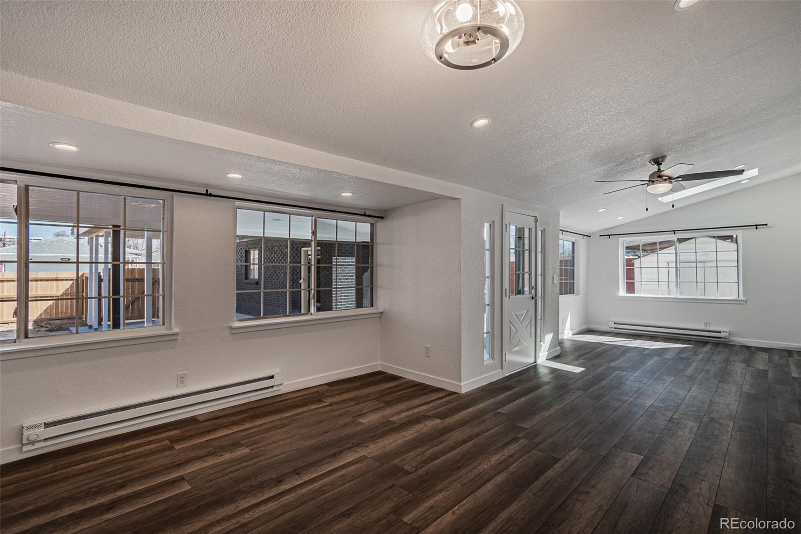 3360 Magnolia Street Denver, CO 80207 - Photo 18 of 31 an empty room with wooden floor and windows