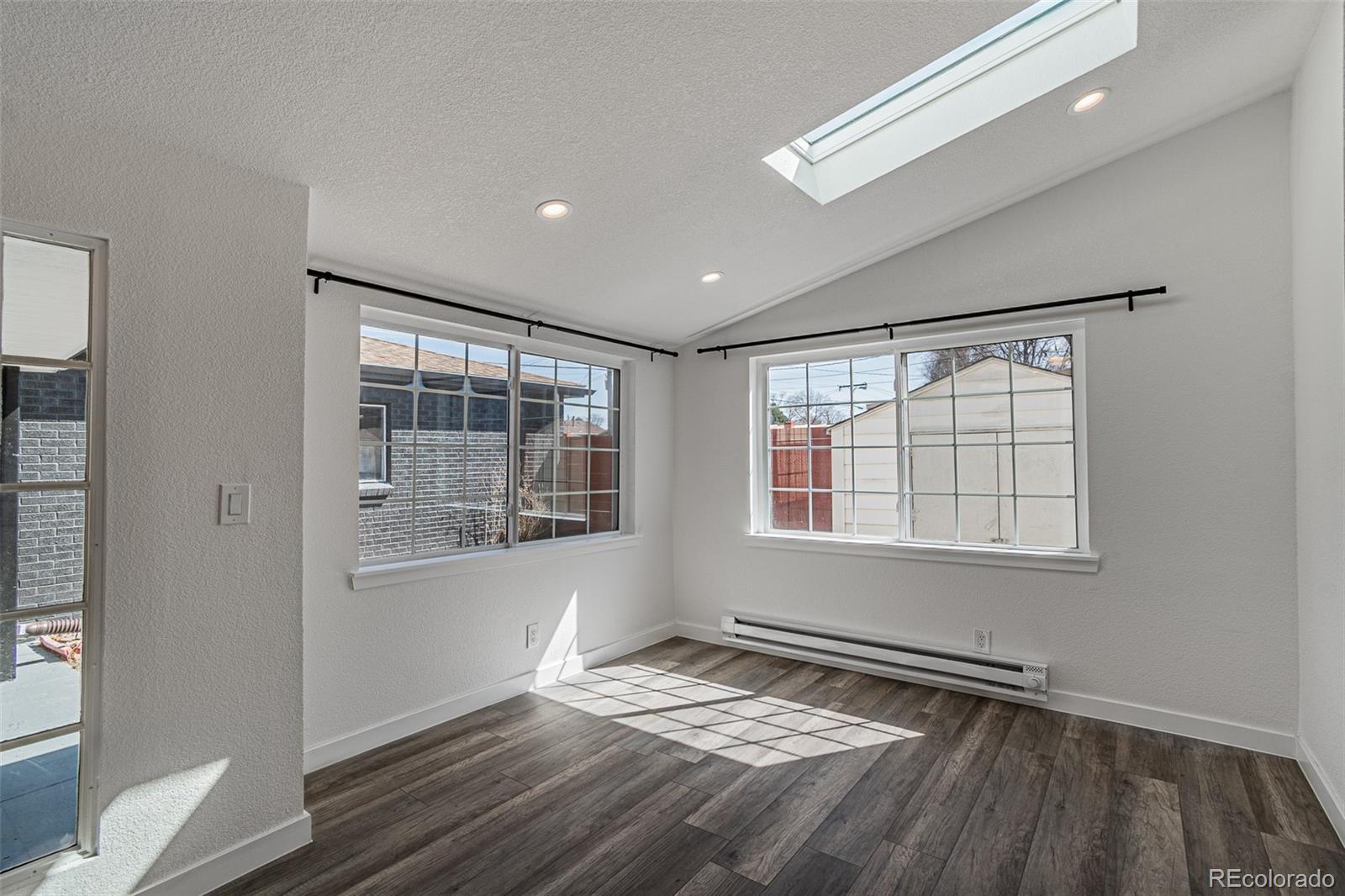 3360 Magnolia Street Denver, CO 80207 - Photo 19 of 31 a view of an empty room with wooden floor and a window