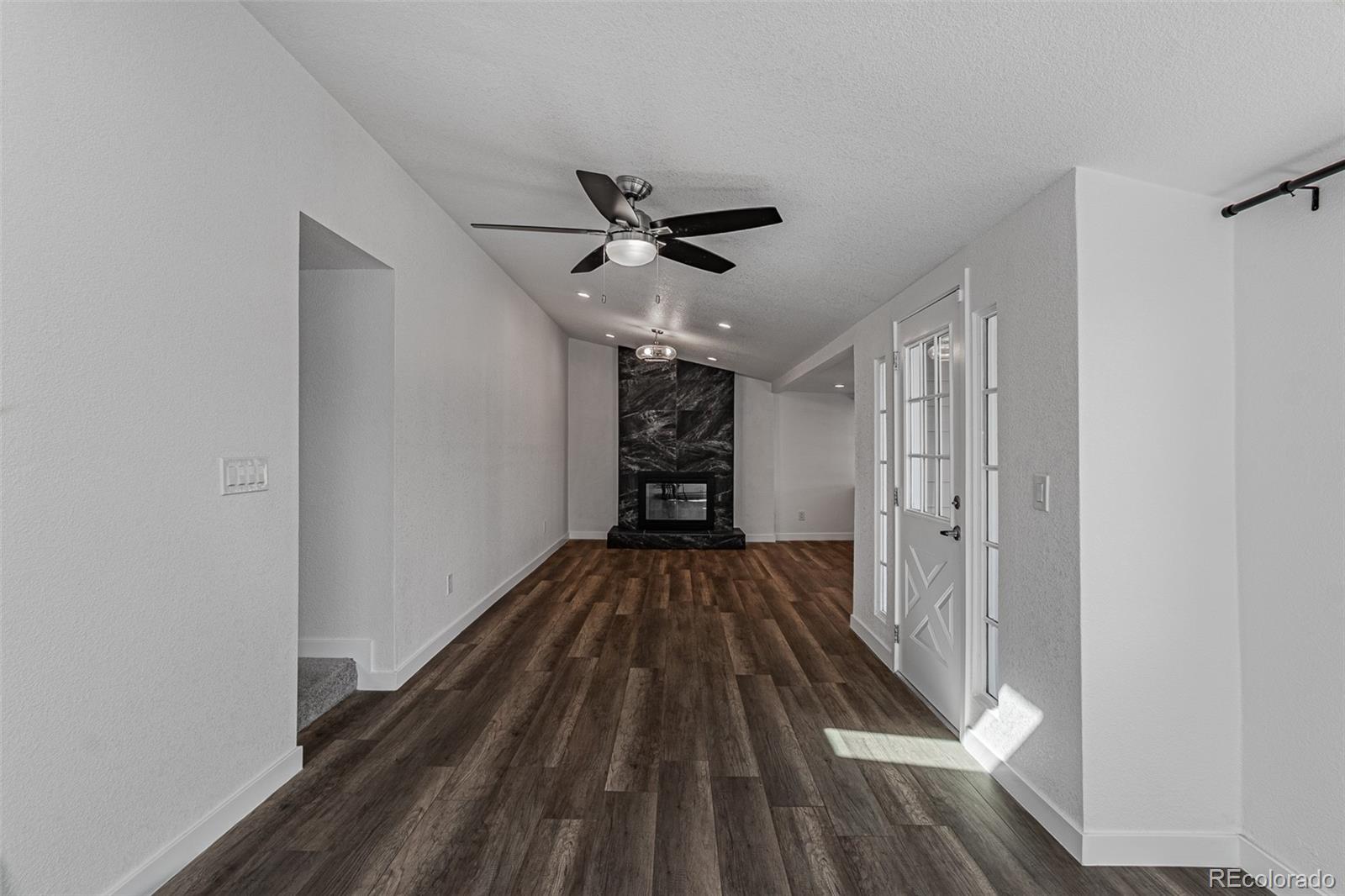 3360 Magnolia Street Denver, CO 80207 - Photo 20 of 31 a view of a room with wooden floor ceiling fan and kitchen space
