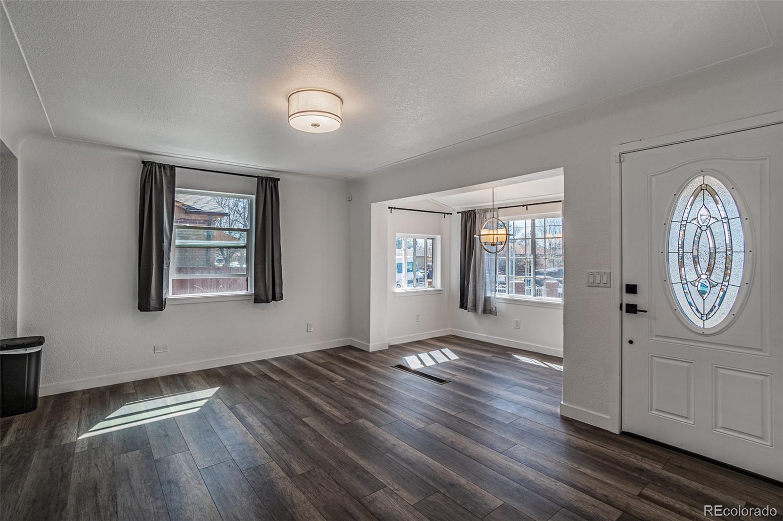 3360 Magnolia Street Denver, CO 80207 - Photo 6 of 31 a view of an empty room with window and wooden floor