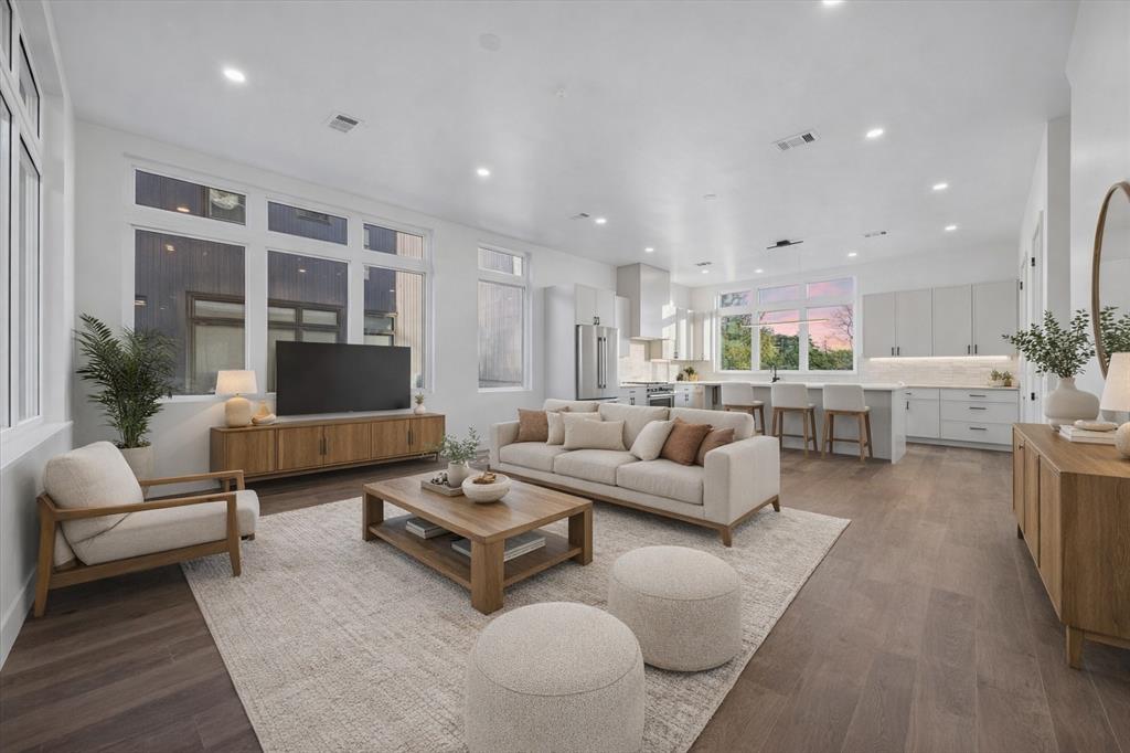 4101 Menchaca Road, Unit 102 Austin, TX 78704 - Photo 13 of 14 An open floorplan seamlessly connects the living area to a modern kitchen, bathed in light from expansive windows.