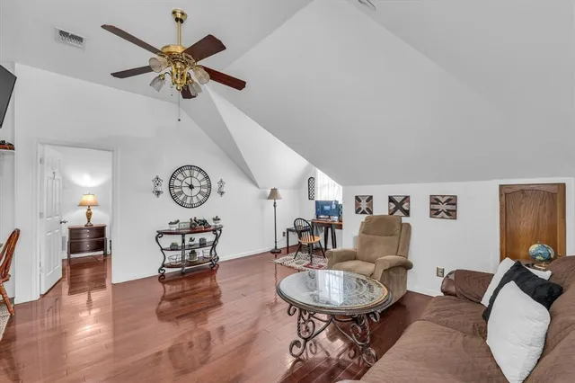 a living room with furniture and a wooden floor