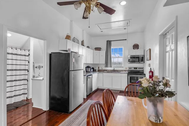 a kitchen with stainless steel appliances kitchen island granite countertop a refrigerator and a sink