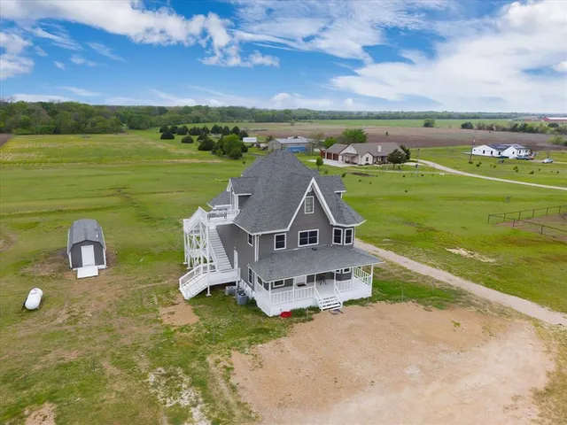 an aerial view of a house with a garden and lake view