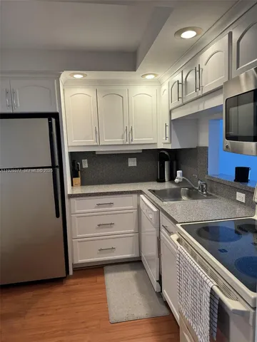 a kitchen with stainless steel appliances granite countertop a sink and a stove top oven