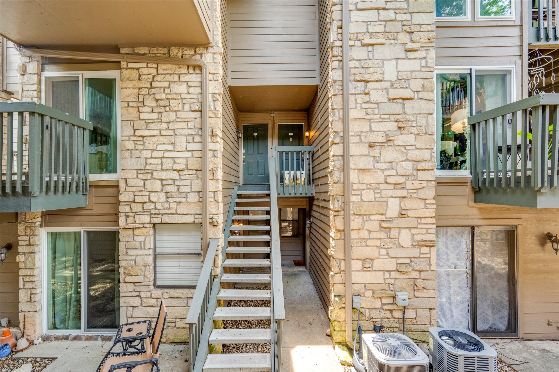 3627 Menchaca Road, Unit 214 Austin, TX 78704 - Photo 28 of 28 Natural stone accents and wooden balconies enhance the multi-level exterior, offering a charming facade.