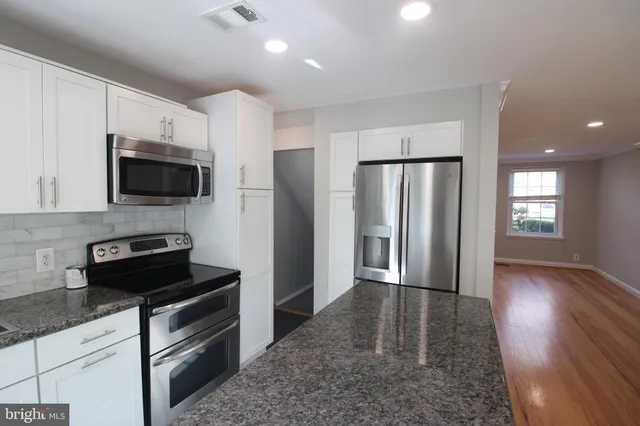 a kitchen with stainless steel appliances granite countertop a refrigerator stove and microwave