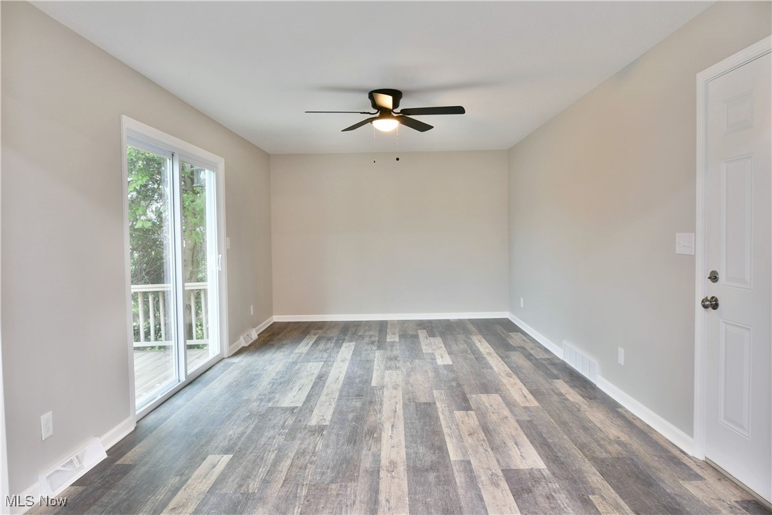 2474 Johnny Cake Road Southeast Warren, OH 44484 - Photo 17 of 50 Unfurnished room featuring dark wood-style floors, baseboards, ceiling fan, and visible vents
