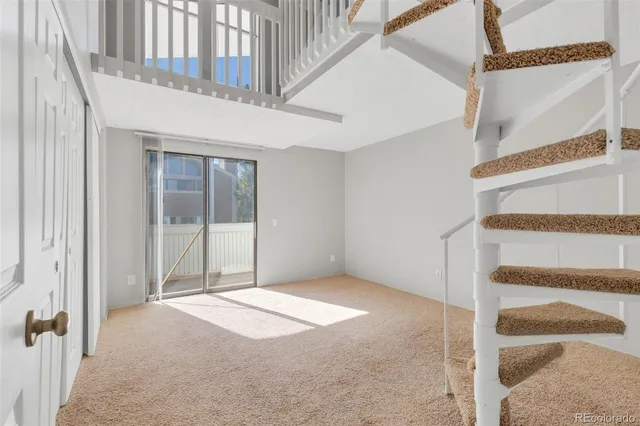 a view of an empty room with stairs and white walls