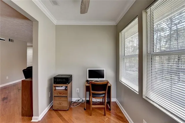 a view of an empty room with a window and wooden floor