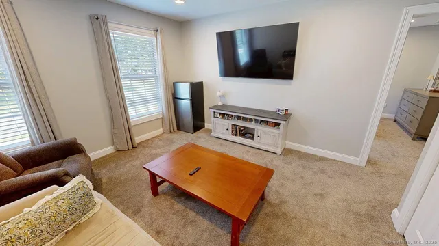 a living room with furniture a window and a flat screen tv