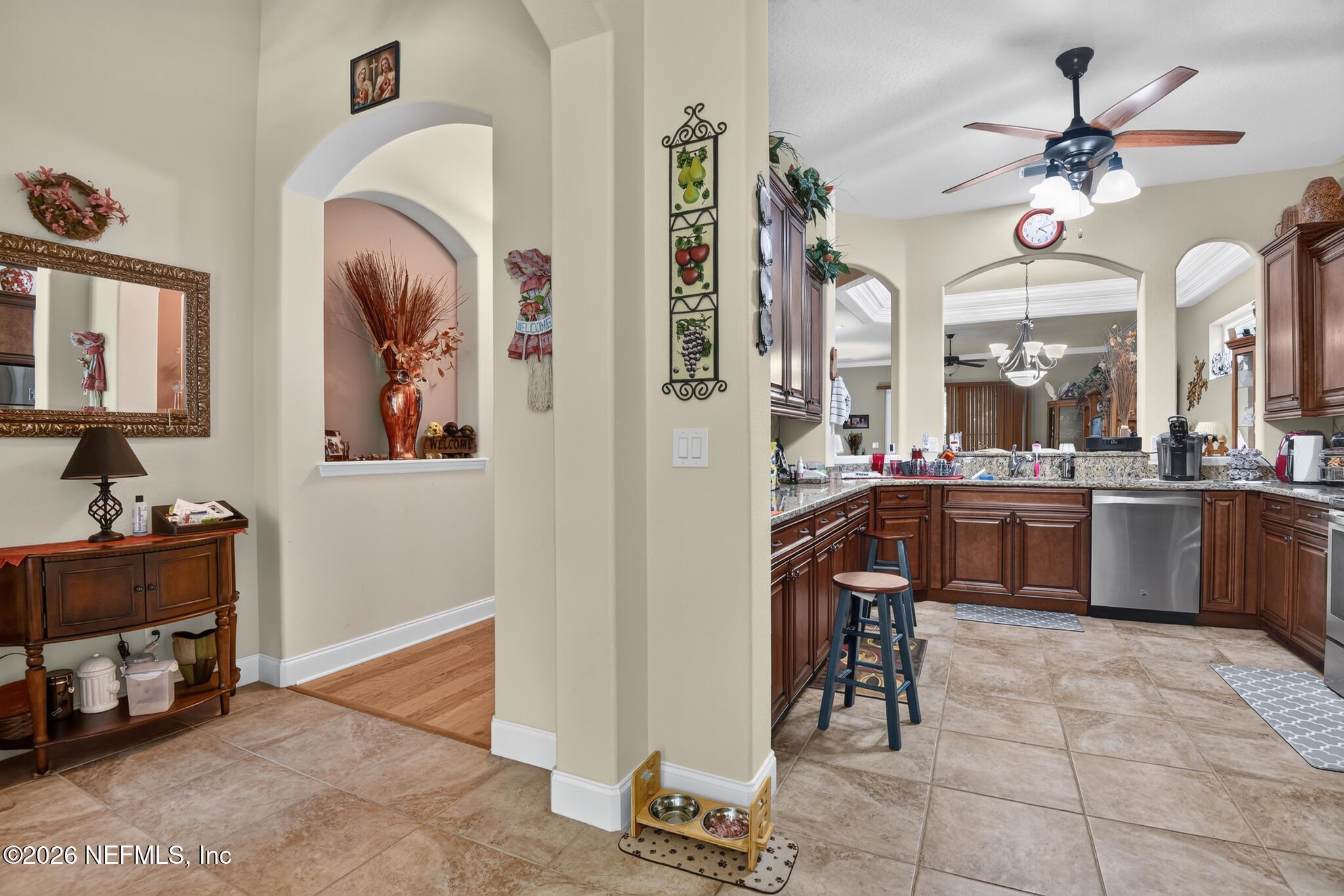 110 Vía Roma Ormond Beach, FL 32174 - Photo 13 of 43 a kitchen with stainless steel appliances kitchen island granite countertop a stove a sink and a refrigerator with wooden floor