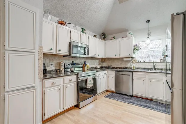 a kitchen with stainless steel appliances granite countertop a sink and cabinets