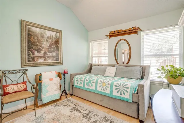 a bedroom with a bed a mirror and a large window