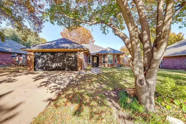 a front view of a house with a tree