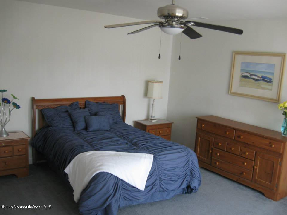 59 A Topsail Road Brick, NJ 08723 - Photo 13 of 18 a bedroom with a bed a lamp and a chandelier