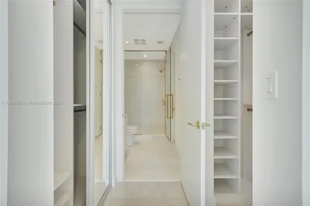 a living room with furniture a potted plant and open kitchen view