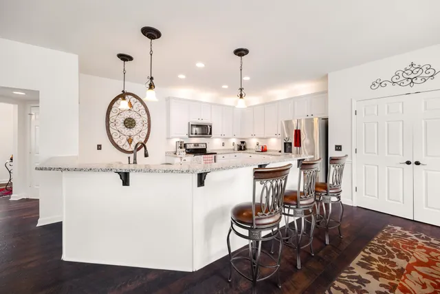 a living room with kitchen island furniture and a clock