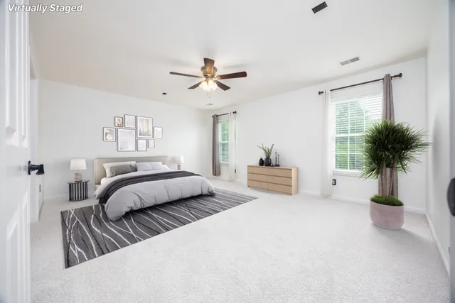 a spacious bedroom with a bed and a potted plant