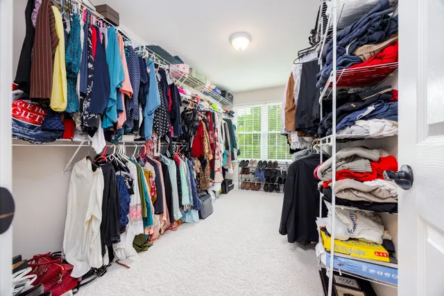 a view of walk in closet with clothes and shoes