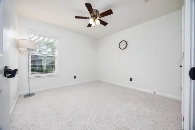 an empty room with a window and a ceiling fan