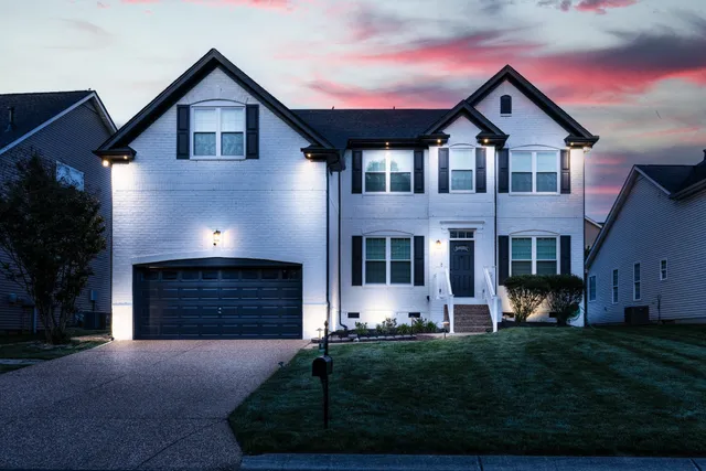 a front view of a house with a yard and garage