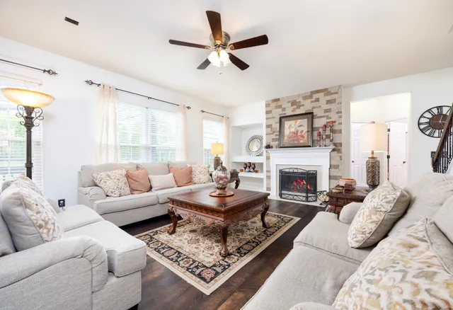 a living room with furniture a fireplace and a flat screen tv