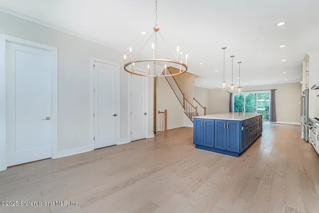 a view of a room with wooden floor furniture and a chandelier