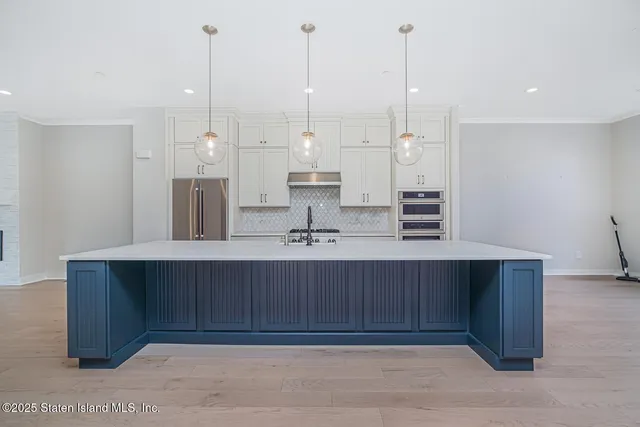 a kitchen with stainless steel appliances granite countertop a refrigerator a sink dishwasher and a stove with wooden floor