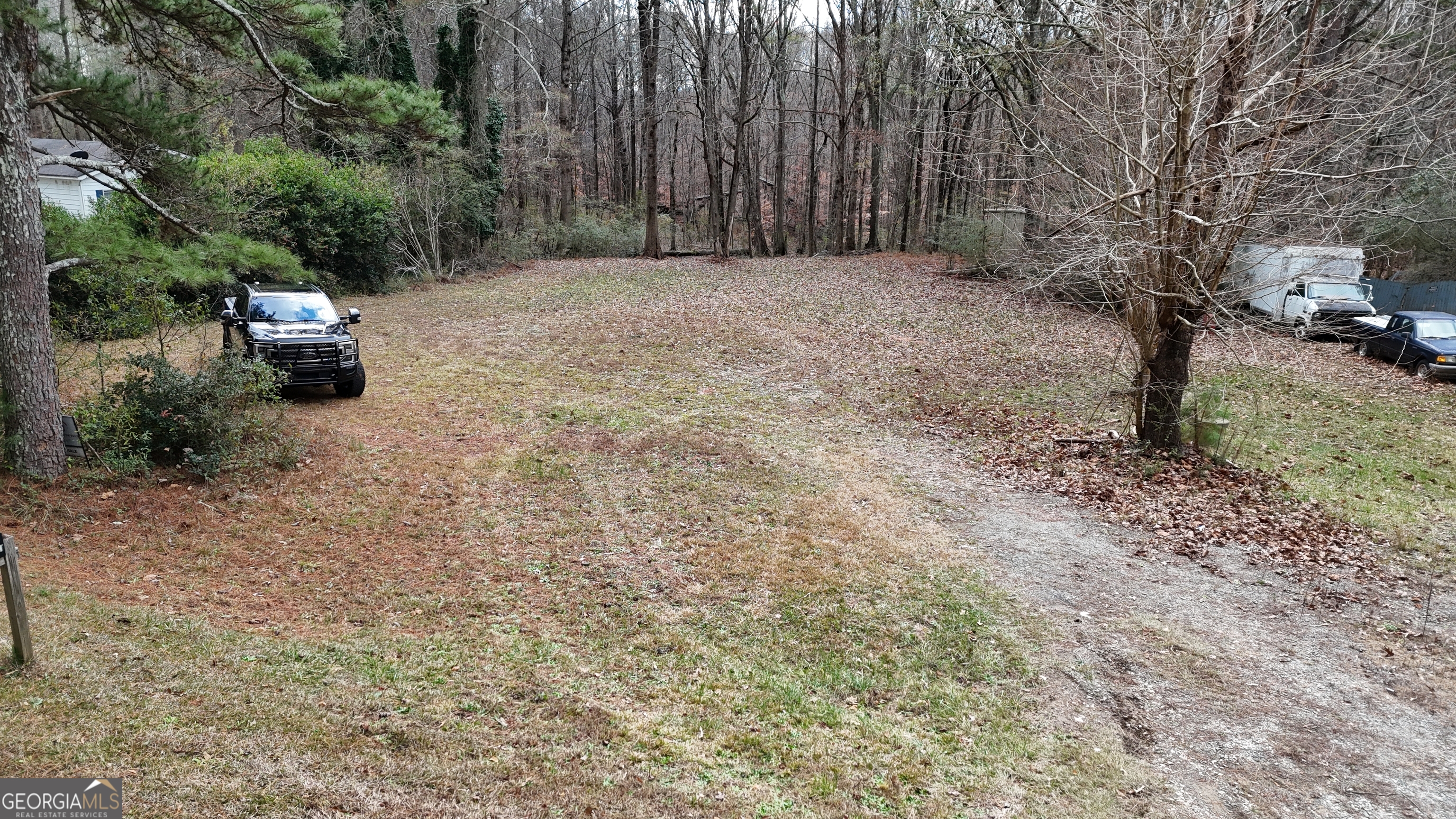 7307 Williams Street Flowery Branch, GA 30542 - Photo 7 of 33 a backyard of a house with trees and outdoor seating