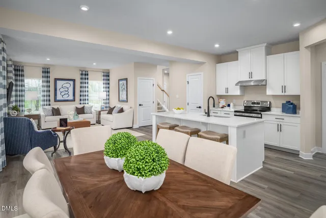 a kitchen with a dining table chairs appliances and cabinets