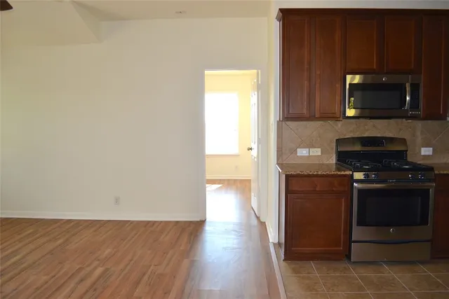 a kitchen with stainless steel appliances granite countertop a stove a microwave and a refrigerator