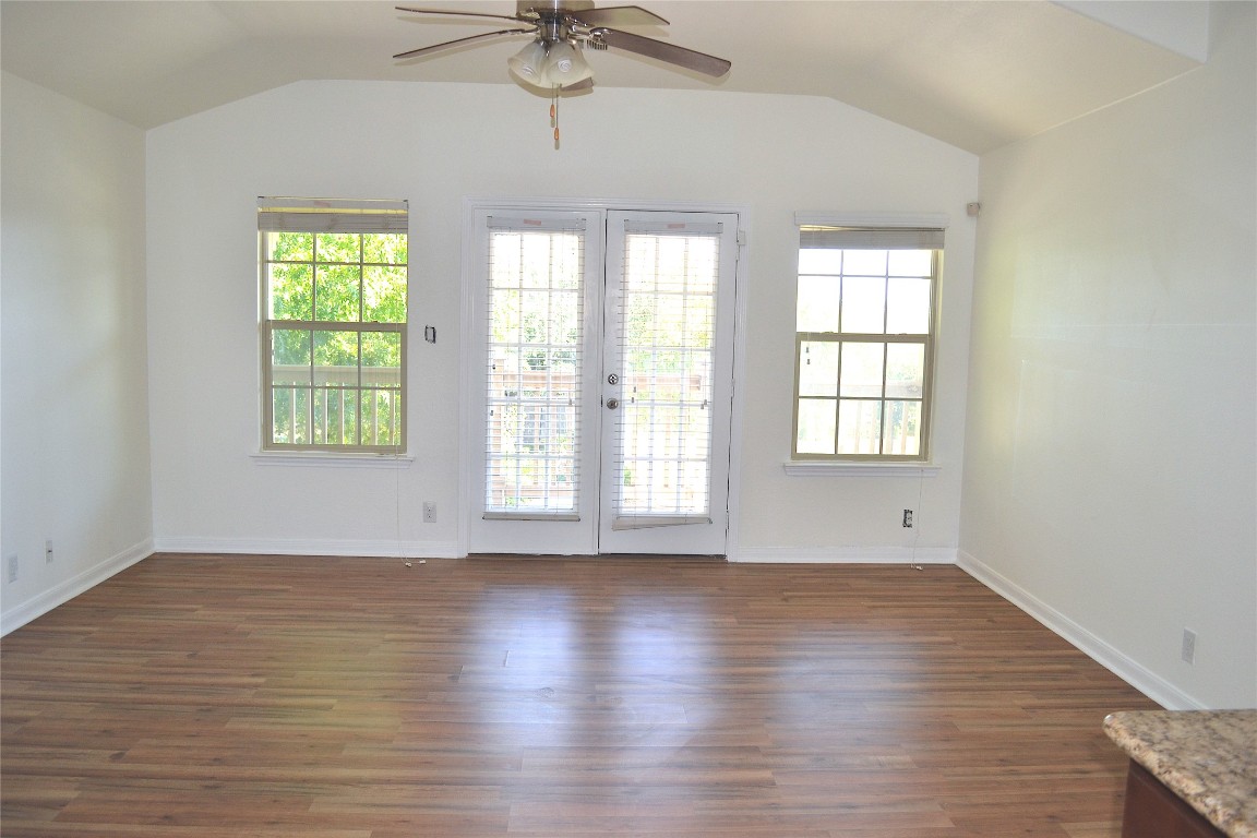 9201 Brodie Lane, Unit 101 Austin, TX 78748 - Photo 13 of 24 an empty room with wooden floor chandelier fan and windows