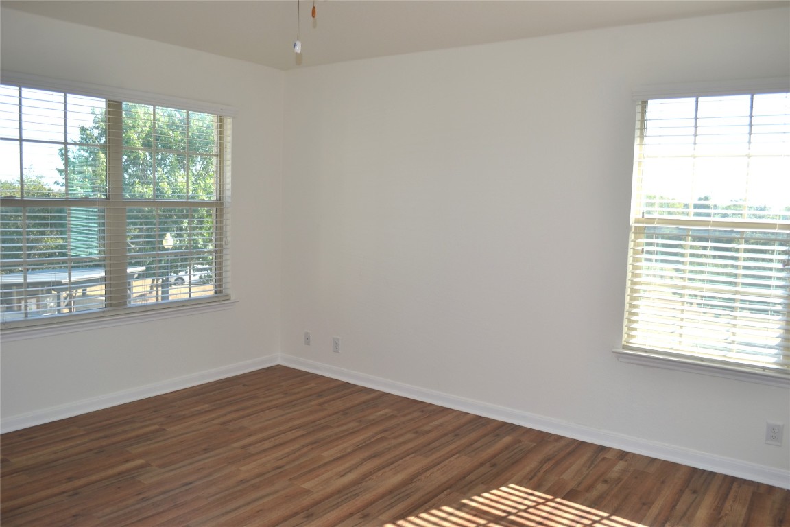 9201 Brodie Lane, Unit 101 Austin, TX 78748 - Photo 15 of 24 a view of an empty room with wooden floor and a window