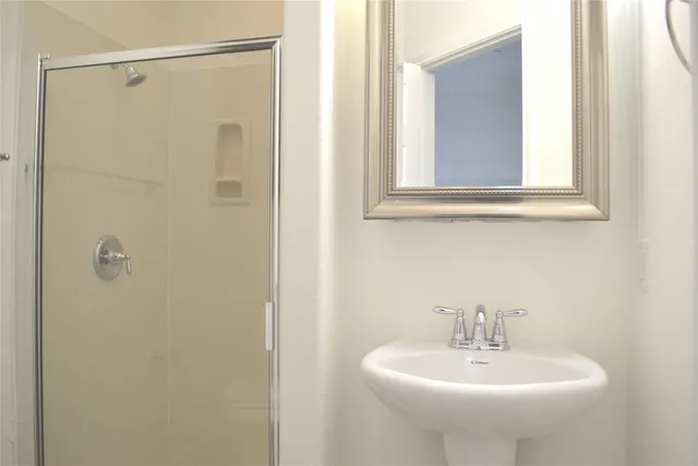 a bathroom with a sink a mirror and shower
