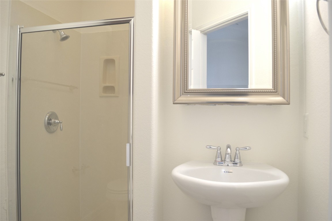 9201 Brodie Lane, Unit 101 Austin, TX 78748 - Photo 22 of 24 a bathroom with a sink a mirror and shower