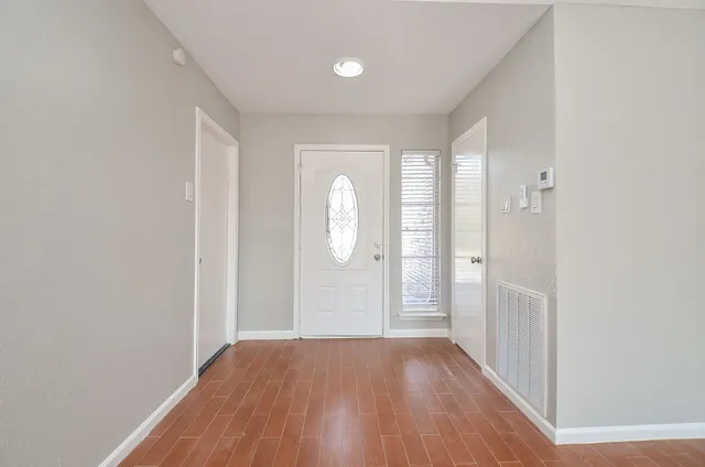 a view of a room with wooden floor and window