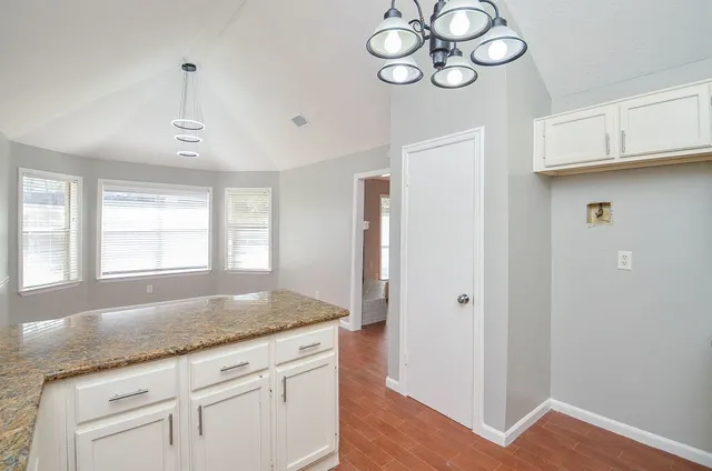 a kitchen with granite countertop cabinets a window and a sink