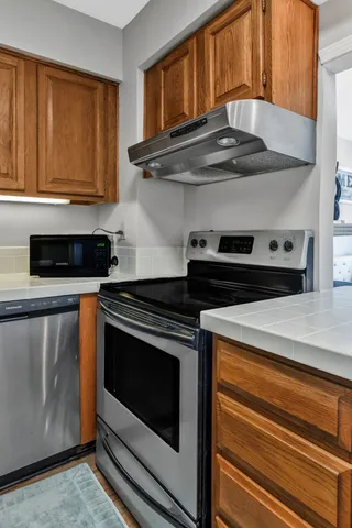 a kitchen with stainless steel appliances granite countertop a stove a microwave and a white cabinets