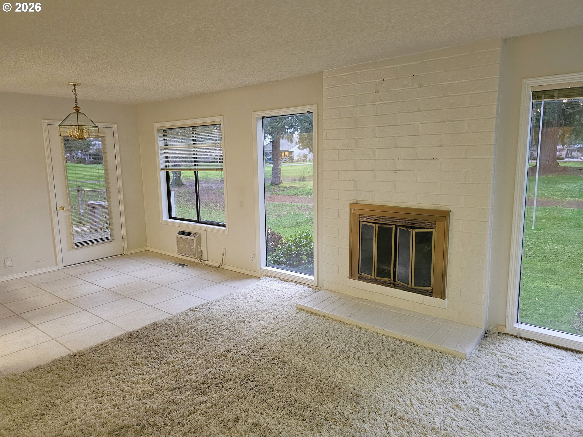 8360 Southwest Mariners Drive Wilsonville, OR 97070 - Photo 5 of 10 an empty room with windows and fireplace