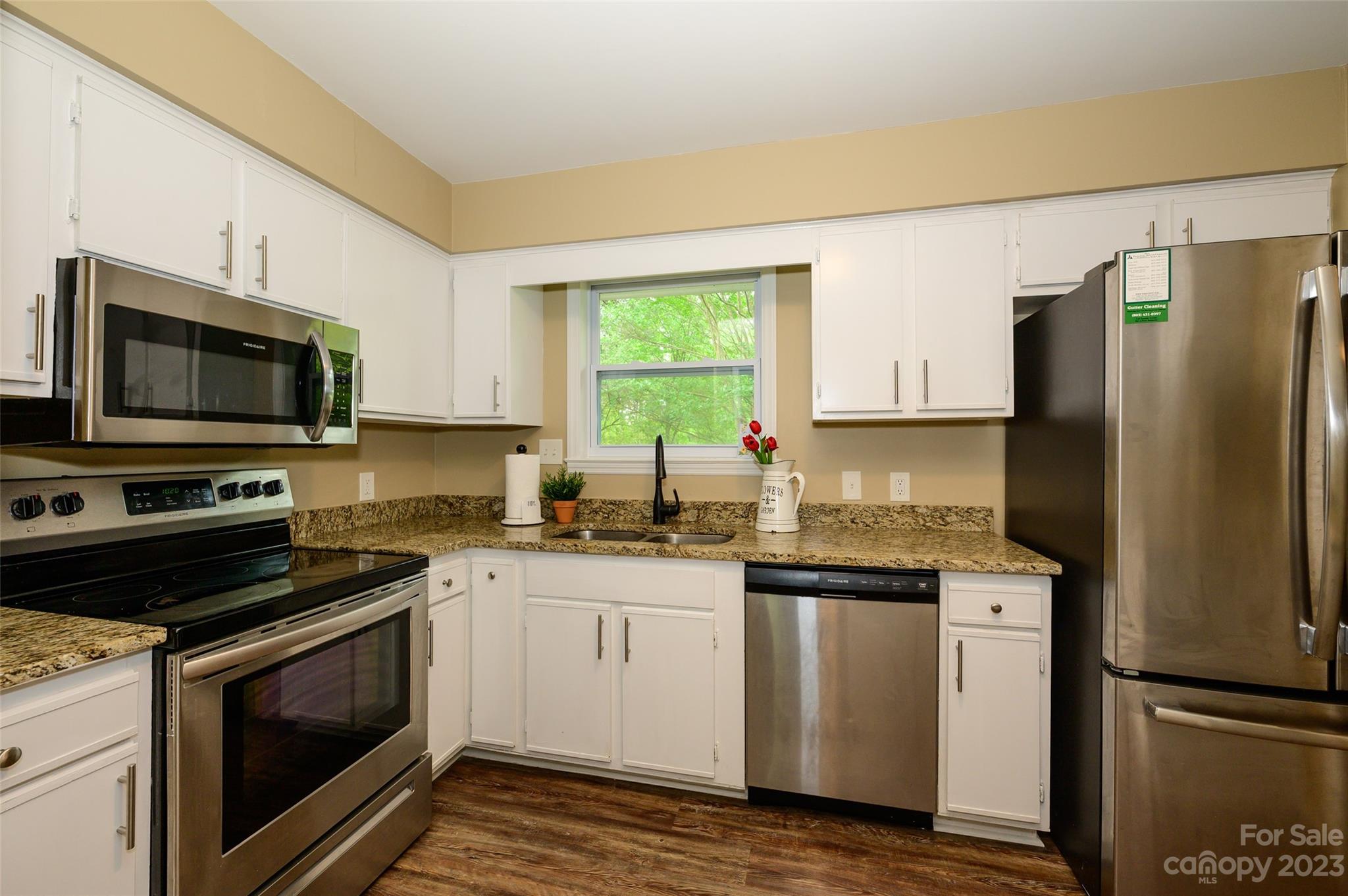 16079 Molokai Drive Tega Cay, SC 29708 - Photo 17 of 41 a kitchen with granite countertop a refrigerator stove and microwave