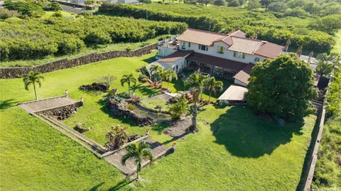an aerial view of a house with a garden and lake view